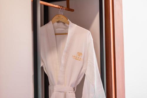 a white sweater hanging on a rack in a door at Emerald Residence Kampot in Kampot