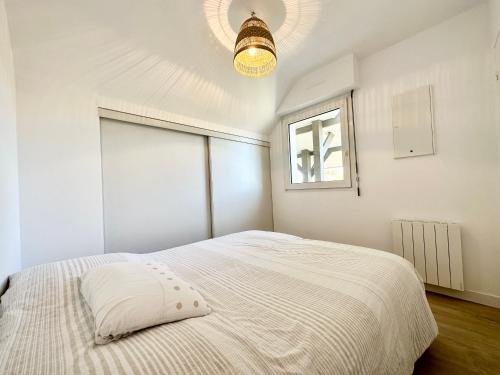 - une chambre blanche avec un lit et une fenêtre dans l'établissement T2 neuf Top Cocooning – Terrasse – Face à la mer, à Ploemeur