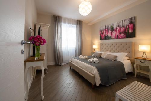 a bedroom with a bed and a vase of pink flowers at Dream Holiday Home in Rome