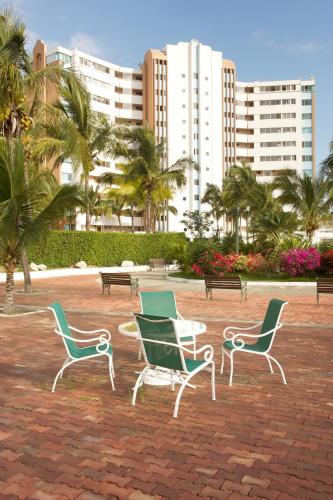 a group of chairs sitting in a park with buildings at Condominio Carabelas de Colón in Playas