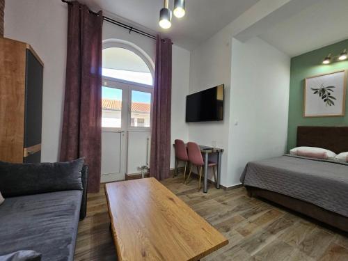 a room with a bed and a couch and a table at Apartments San in Sukošan