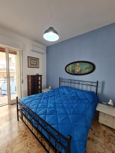 - une chambre avec un lit et une couette bleue dans l'établissement La Casuccia, à Syracuse