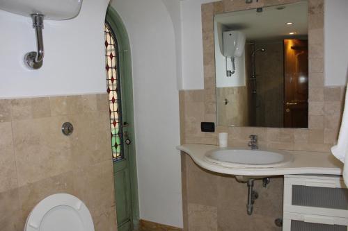 a bathroom with a sink and a toilet and a mirror at Sogno Romano in Rome