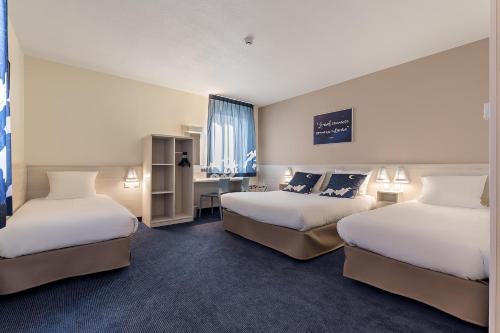 Cette chambre comprend deux lits et un bureau. dans l'établissement ACE Hôtel Metz, à Metz