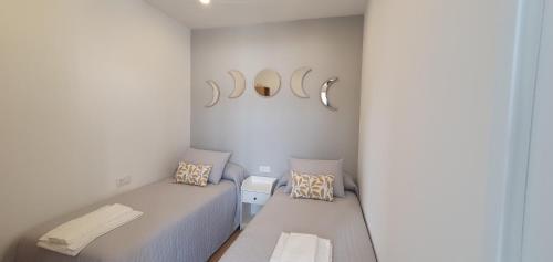 Habitación blanca pequeña con 1 cama y 2 almohadas en Pisos uso turistico Torno-Cubelas-Caosa Buenavista en San Ciprián