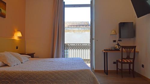 una camera con letto e vista su un balcone di Hotel Medici a Milazzo