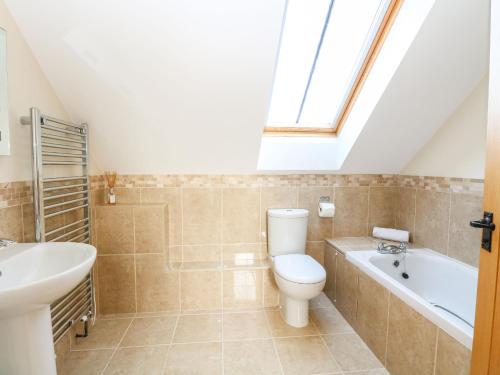 ein Badezimmer mit einem WC, einem Waschbecken und einer Badewanne in der Unterkunft The Old Cartshed in Lowestoft