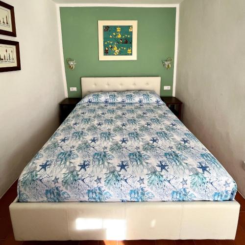 a bedroom with a bed with a blue and white bedspread at Divina Casa Vacanze Donna Silvana in Sperlonga