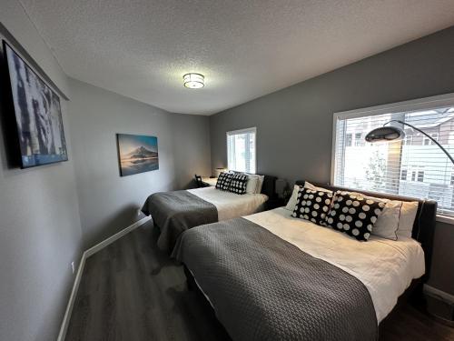 1 dormitorio con 2 camas y ventana en Luxury Two Queen Beds Condo - Grande Rockies Resort Indoor Parking Pool Hot tub GYM, en Canmore