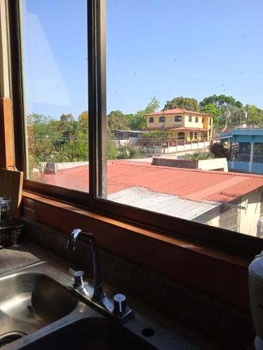 okno nad umywalką z widokiem na budynek w obiekcie DIMASHQ w mieście Penonomé