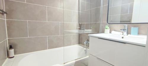 ein Badezimmer mit einer Badewanne, einem Waschbecken und einem Spiegel in der Unterkunft Chez Adriana Studio VUE MER avec Piscine in Grimaud