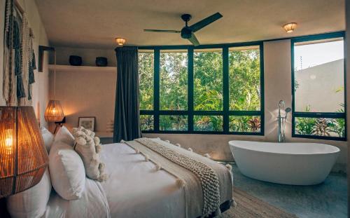 a bedroom with a large bed with a tub and a window at Round Villa Private Pool & Jungle rooftop 2A in Tulum