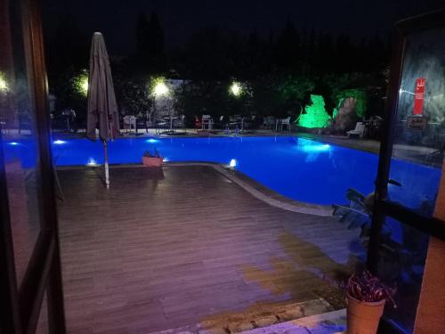 a swimming pool at night with an umbrella at Hotel Diar Meriam in Sousse