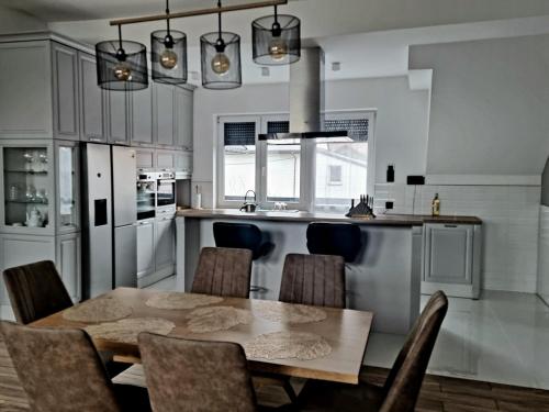 uma cozinha com mesa e cadeiras num quarto em Apartamenty ASLux - Noclegi Energylandia Zator em Zator