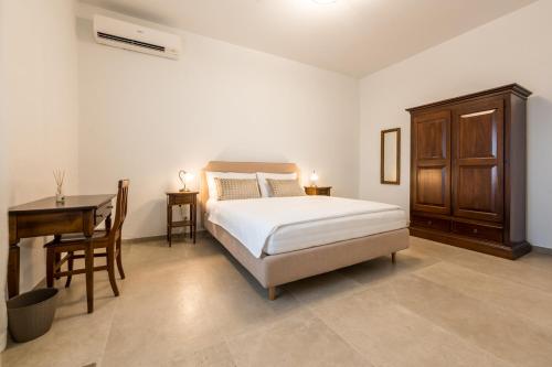 een slaapkamer met een bed, een tafel en een bureau bij Agriturismo La Collina degli Olivi in Certaldo