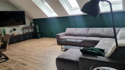 a living room with a couch and a flat screen tv at Apartamenty ASLux - Noclegi Energylandia Zator in Zator