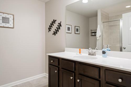 a bathroom with a sink and a mirror at New Construction 3BR Home Near Chattahoochee River in Norcross