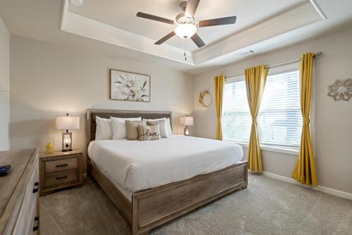 a bedroom with a large bed and a ceiling fan at New Construction 3BR Home Near Chattahoochee River in Norcross