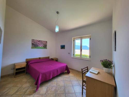 カーポ・ヴァチカーノにあるVilla Faroのベッドルーム(紫色のベッド1台、窓付)