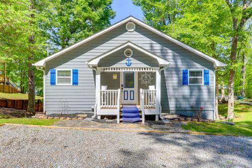 a small grey house with blue shutters on it at Lakefront Eatonton Getaway with Dock and Grill! in Resseaus Crossroads