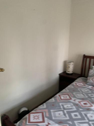 a bedroom with a bed and a nightstand next to it at Safari Apartments -Beautiful 3 bedrooms, 10-seater dining , TV room, Garden & Pool in Johannesburg