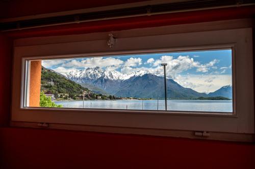 - une fenêtre avec vue sur le lac et les montagnes dans l'établissement Lakeside apartment with balcony and lake view Gravedona - Larihome A23, à Gravedona