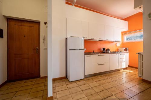 une cuisine avec des armoires blanches et un réfrigérateur dans l'établissement Lakeside apartment with balcony and lake view Gravedona - Larihome A23, à Gravedona