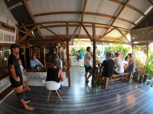 a group of people sitting in a restaurant at Mentawai Bagus Local Homestay in Tua Pejat