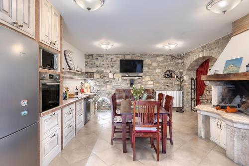 a kitchen with a table and chairs and a stone wall at Apartman Pietro in Motovun