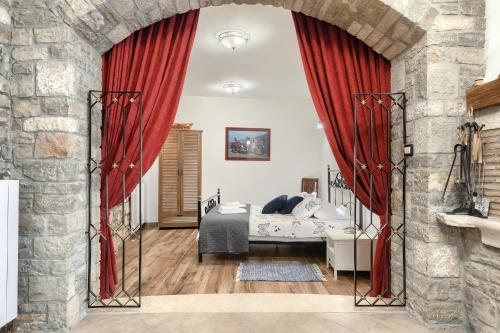 sypialnia z łóżkiem i czerwoną zasłoną w obiekcie Apartman Pietro w mieście Motovun