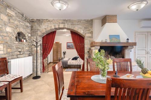 a living room with a table and a stone wall at Apartman Pietro in Motovun