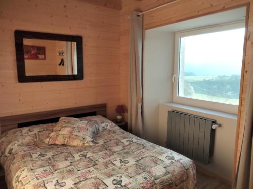 1 dormitorio con cama y ventana en Gîte du Bachat, en Vorey