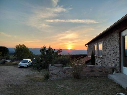 VoreyにあるGîte du Bachatの夕日の見える家の前に停めた車