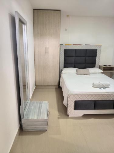 a bedroom with a large bed and a mirror at HELENE HOUSE in Sincelejo