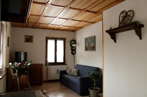 - un salon avec un canapé bleu et une fenêtre dans l'établissement Haisle im Untrborkh, à Sauris