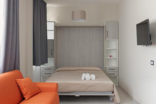 a bedroom with a bed and an orange chair at areacafè affitta camere in Canicattì