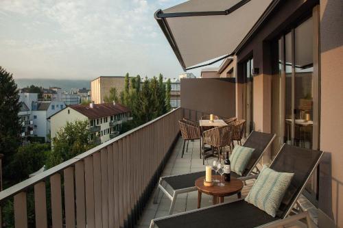 a balcony with chairs and a table on a building at Acasa Suites in Zurich