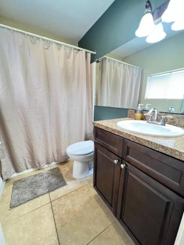 ein Bad mit einem Waschbecken, einem WC und einer Dusche in der Unterkunft Spacious and relaxing Home - Longwood, Florida in Orlando