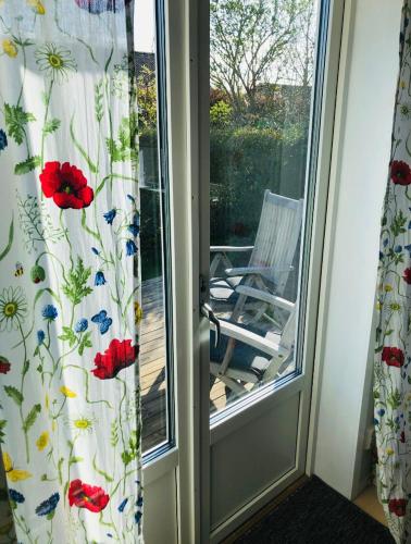 a sliding glass door with curtains with flowers on it at Blå Dörren in Torekov