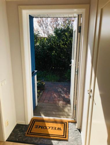 an open door to a porch with a welcome mat at Blå Dörren in Torekov