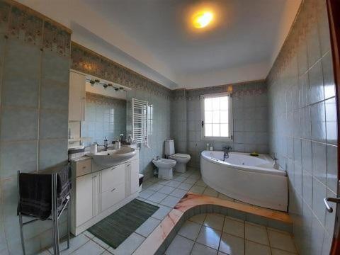 uma casa de banho com uma banheira, 2 lavatórios e um WC. em Etnadia em Santa Maria di Licodia