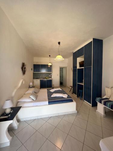 ein großes Schlafzimmer mit einem großen Bett und einem Sofa in der Unterkunft Christos rooms milos in Adamas