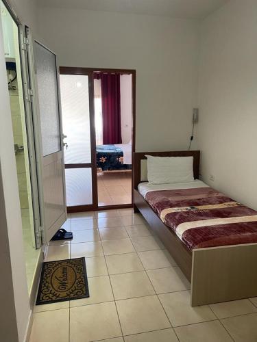um quarto com uma cama e uma porta de vidro deslizante em Maria Guest House em Përmet