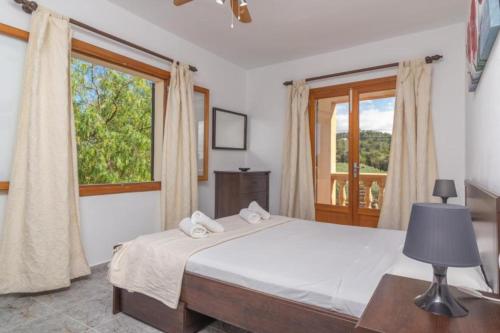a bedroom with a bed and a large window at Pili in Felanitx