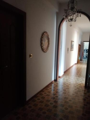 una stanza vuota con un lampadario a braccio e un corridoio di Avellino casa centralissima ad Avellino