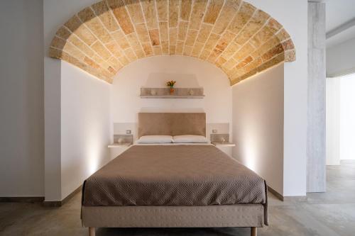a bedroom with a large bed with a brick ceiling at Aurosa Vacanze in Alliste