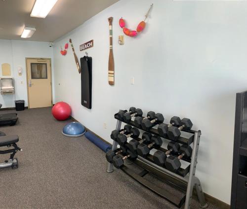 a room with a gym with equipment on the wall at Hotel Marguerite South Anaheim - Garden Grove, Trademark Collection by Wyndham in Anaheim