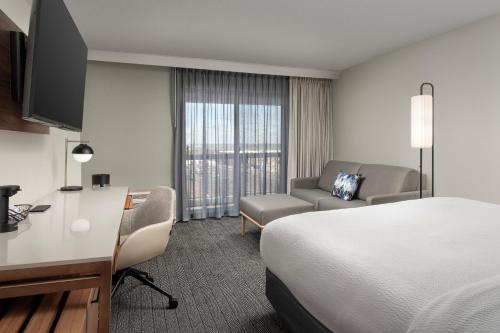 a hotel room with a bed and a desk and a chair at Courtyard by Marriott Dayton Beavercreek in Beavercreek