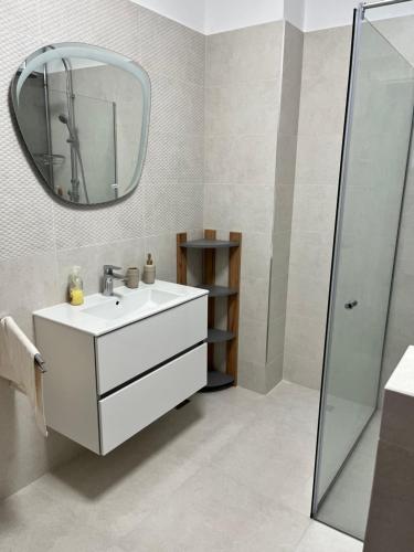 een badkamer met een witte wastafel en een spiegel bij Lake On in Mamaia