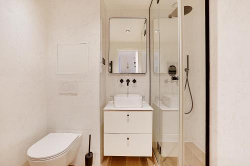 biała łazienka z toaletą i prysznicem w obiekcie CMG - Bastille / Le Marais - D w Paryżu